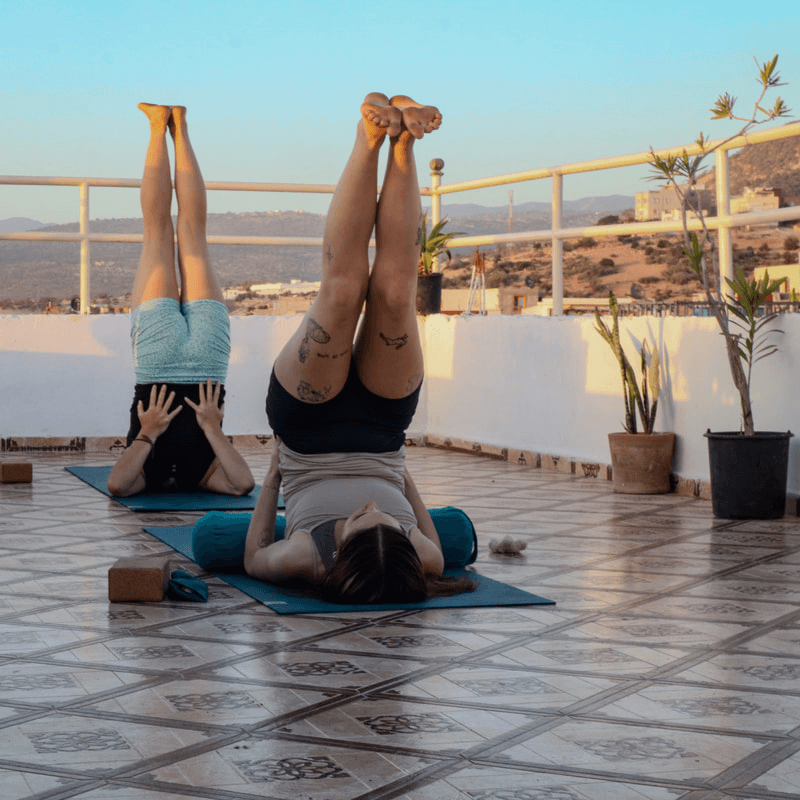 Women doing a yoga session on a rooftop in Taghazout