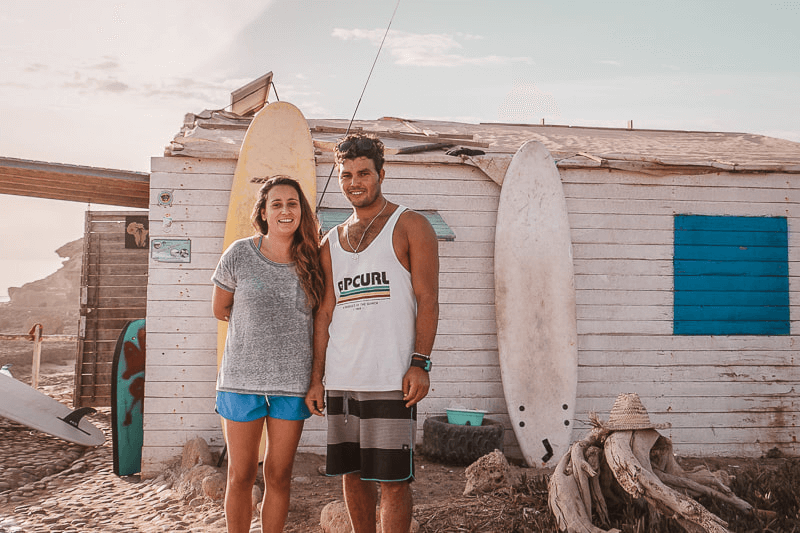 Smiling couple in front of a beach house in Taghazout 