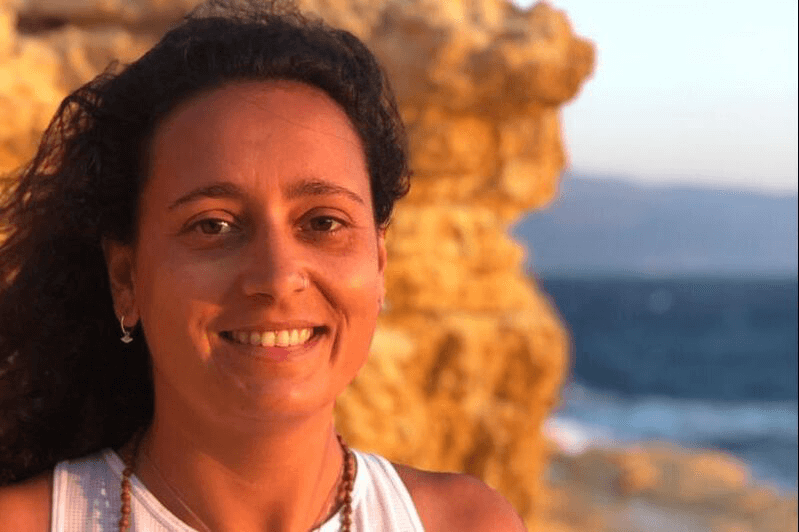 Smiling yoga teacher in front of the ocean in Taghazout
