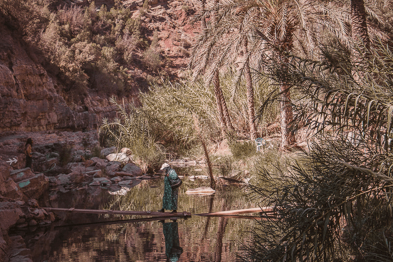 Moroccan woman crossing a river in Paradise Valley